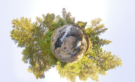 A little tiny planet of an earhtly rocky river with trees and skyの写真素材