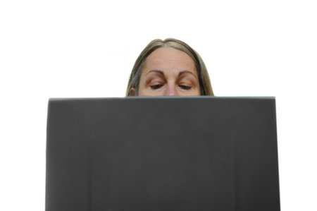 Woman typing on a laptop with her eyes looking down at the keyboard