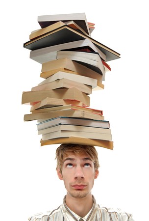 A young adult teenage man with stacks of books on top of his head. Isolated on white background.の写真素材