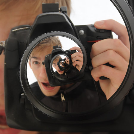 A man holding up a DSLR camera taking a never ending picture. The name for this effect is called the...
