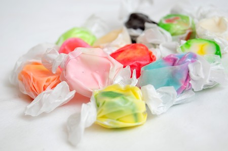 A pile of multicolored saltwater taffy candy on a white cloth.の写真素材
