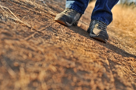 A man standing on a gravel road with his shadow in front of himの写真素材