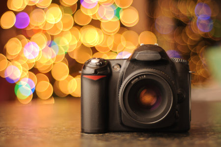 DSLR camera sitting on a black countertop with defocused bokeh background. Copyspace with room for...