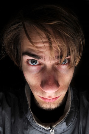Young white Caucasian male is stressed with messy hair. Black copyspace background.の写真素材