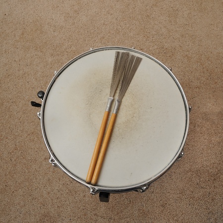 A direct overhead above view of a snare drum on a stand with drum brushes.の写真素材