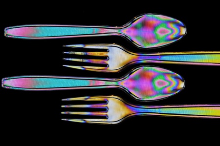 Photoelasticity birefringence shows stressed plastic of a fork and spoon cross polarizedの写真素材