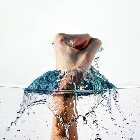 An angry fist punching water isolated on white backgroundの写真素材