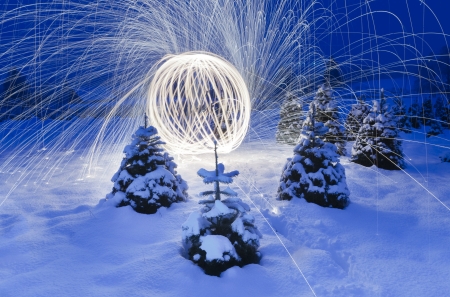 Image of beautiful lighting works display in a natural setting with lots of snow and Christmas trees around.の写真素材