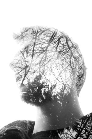 A mans face staring and pondering in wonder as nature creates him. 