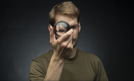 Young man holding a clear transparent crystal glass ball in their handの写真素材