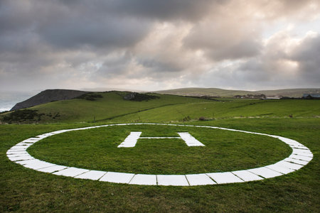 Helicopter landing pad in a grass field on the coast of Tintagel, Cornwall, UK