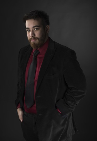 Young Goatee Man Wearing Elegant Maroon and Black Formal Attire While Looking at the Camera. Isolated on Black Background.の写真素材