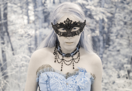 Head and Shoulders Portrait of Woman Wearing Intricate Mask and Gown Outdoors in Forest Setting - Portrait of Mythical Looking Woman in Masquerade Costumeの写真素材
