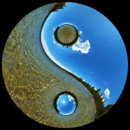 Yin Yang Balance Concept Image of Pristine Wilderness Lake Scenic with Clear Water, Coniferous Forest, and Blue Sky with White Cloudsの写真素材