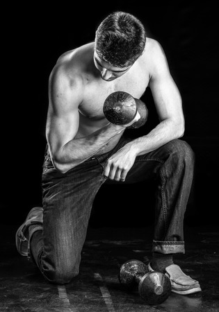 Young Man Working Out Biceps - Dumbbell Concentration Curlの写真素材