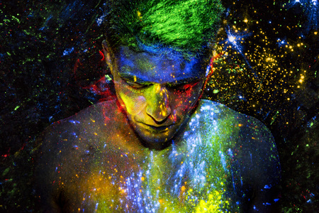 Man covered in glowing colorful powderの写真素材