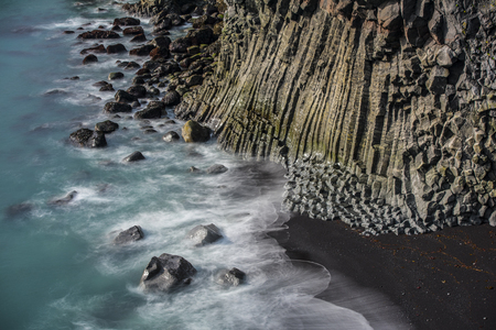 Ocean waves breaking on basalt rocksの写真素材