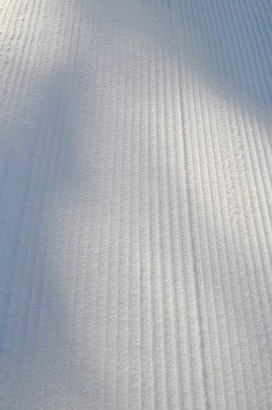 Ski track prepared for cross-country skiing on a sunny winter day. Sparkling snow under the sunlightの写真素材