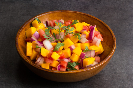 Homemade Mango salsa served in a wooden plateの写真素材