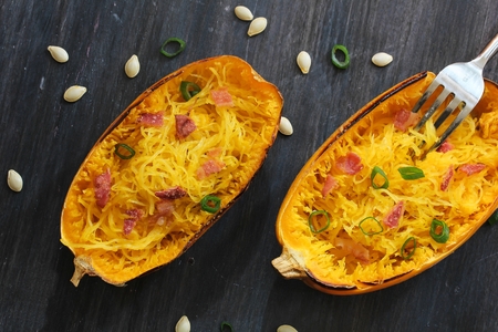 Spaghetti squash with bacon and spring onion topping top down viewの写真素材