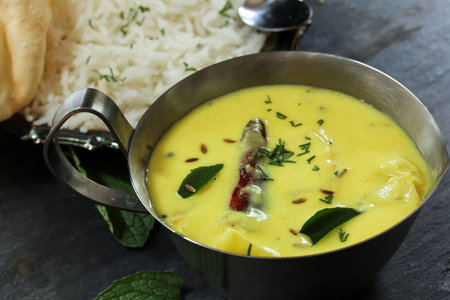 Gujarati Kadhi served with rice and Papad - Indian vegetarian curry made of buttermilk and Chick pea...