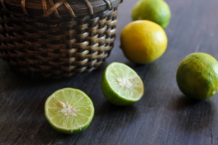 Key limes in a basket on dark moody background, selective focusの写真素材