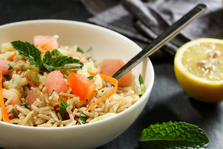 Rice salad / Healthy Brown rice salad with veggies and fruits served in a white bowl, selective focusの写真素材