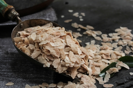Brown Poha or Aval / flattened Rice flakes in a metal scoop, selective focusの写真素材