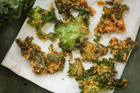 Homemade Kale chips served in parchment paper with tomato sauceの写真素材