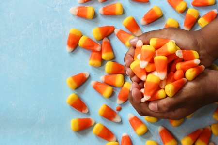 Child's hands holding halloween candy corn, selective focusの写真素材