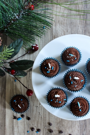 Mini Frosted Chocolate cupcakes on Christmas Holiday backgroundの写真素材