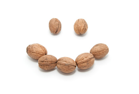 Group of walnuts in the form of a smile on a white background