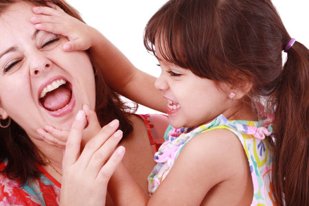Young mother playing with her baby daughter Focus on the motherの写真素材