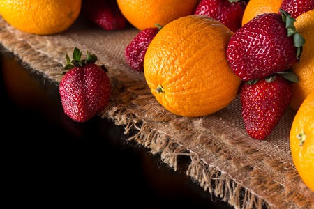 Fresh oranges and ripe strawberry on the jute cloth right high cの写真素材