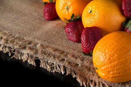 Oranges and strawberry on the black table- fruits backgroundの写真素材