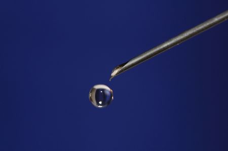 medicine drop hanging  on tip of syringe needle macro shotの写真素材