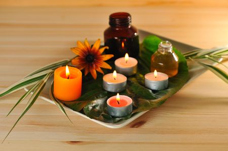 burn scented candles  with brown bottle with essential oil on wood backgroundの写真素材