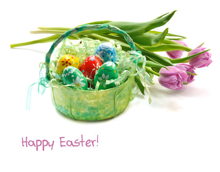 painted easter eggs in basket with pink tulips on white background