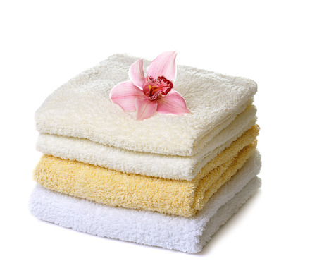 stack of  towels with pink orchid flower isolated on whiteの写真素材