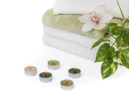 stack of towels with orchid and burn candles isolated on white backgroundの写真素材