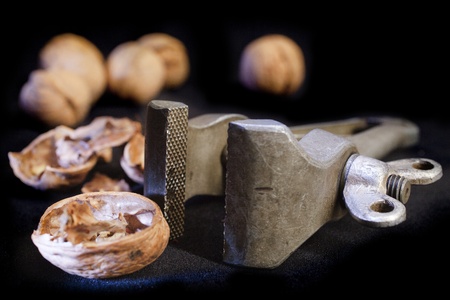 cracked walnut in vice over black backgroundの写真素材