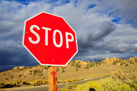 Prohibitory stop traffic sign under cloudy sky.