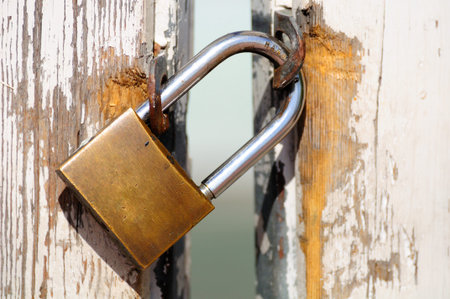 Old wooden gate locked with padlock.