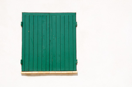 Window of French house shuttered with wooden shutters.の写真素材