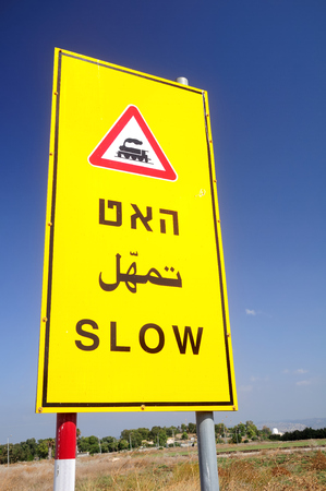 Israeli railroad crossing sign written in three languages - Hebrew, English and Arabic.の写真素材