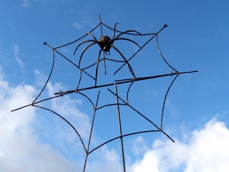 Metal spider in a web against the skyの写真素材