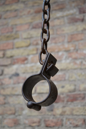 Old shackles against a brick wall