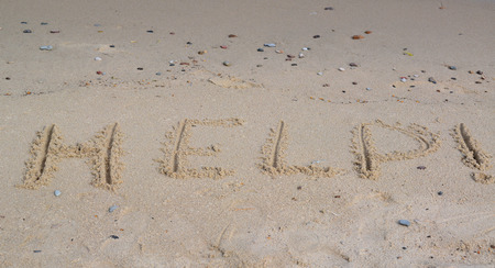 Inscription "HELP! " on a sandy beachの写真素材