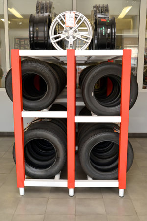 KALININGRAD, RUSSIA - OCTOBER 03, 2015: A rack with tires and rims in shop of an autotechnical centerのeditorial素材