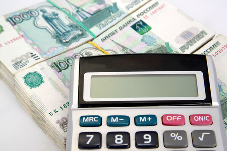 The calculator lies on packs of thousand-ruble Russian notesの写真素材